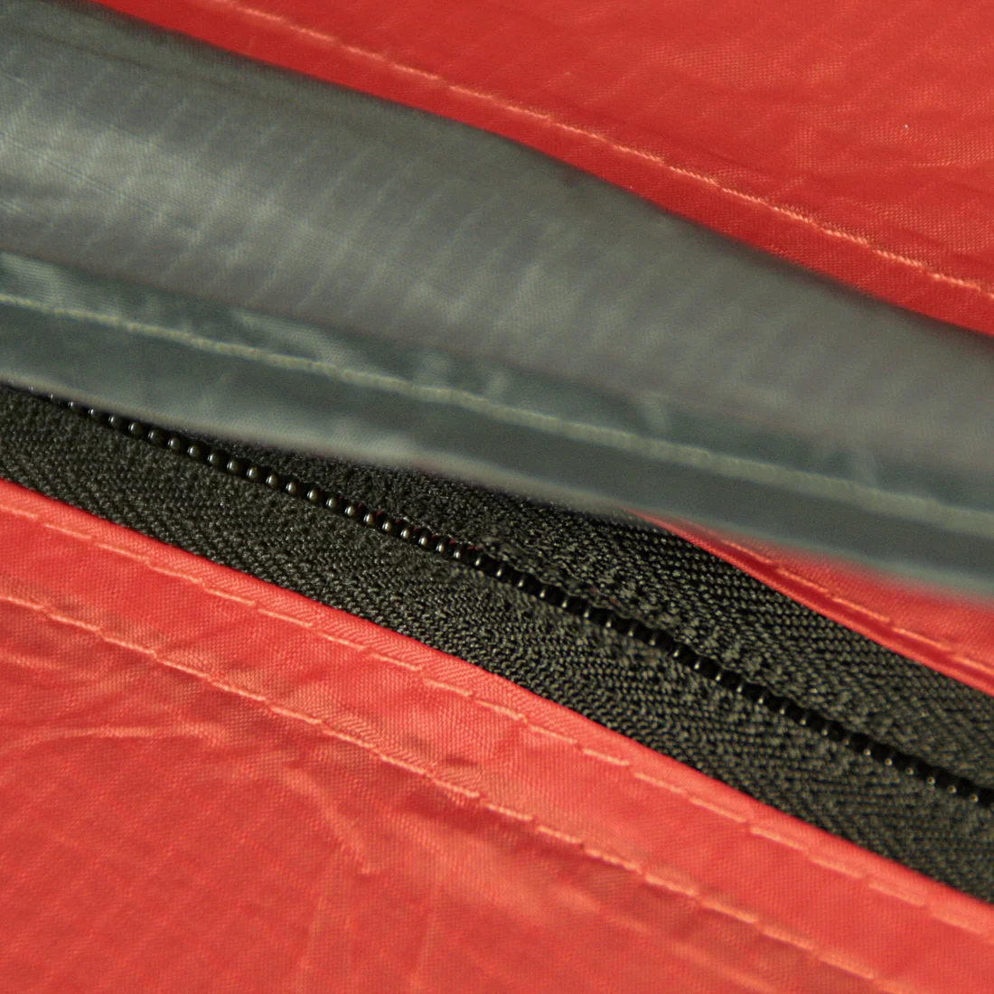 Dettaglio della cerniera impermeabile e delle cuciture rinforzate del 10T Zelt Silicone Valley 3, tenda trekking 3 posti in tessuto rosso siliconato, ideale per campeggio e outdoor.