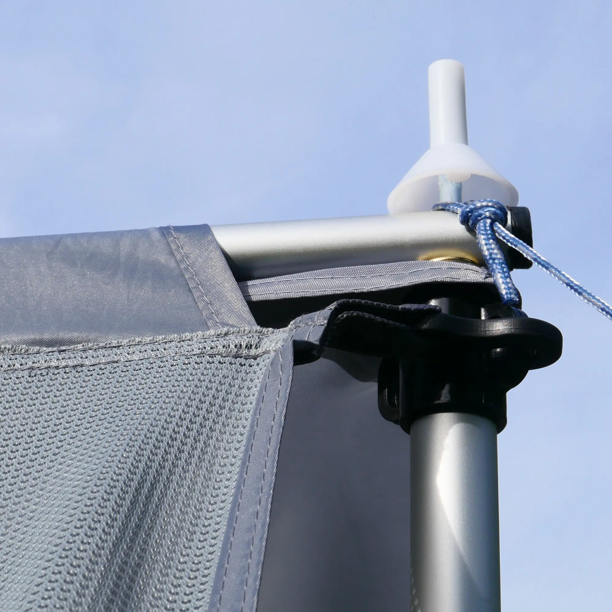 Close-up of the your GEAR Procida sun blocker front wall for caravan awnings, showing durable grey mesh fabric, reinforced stitching, and attachment to a telescopic pole with secure rope fastening.