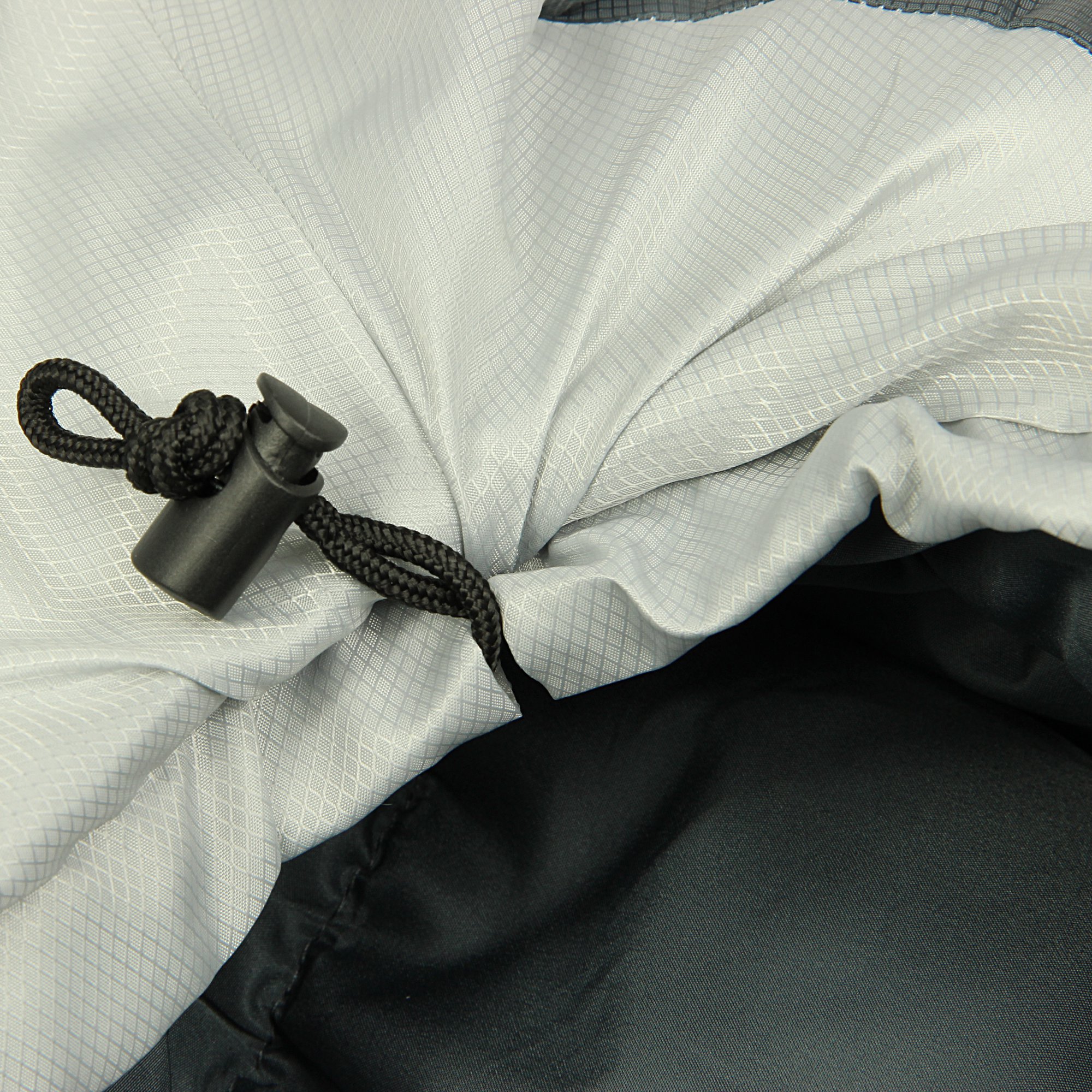 Corda nera con fermacorda in plastica su tessuto tecnico grigio e nero, dettaglio di una chiusura regolabile.