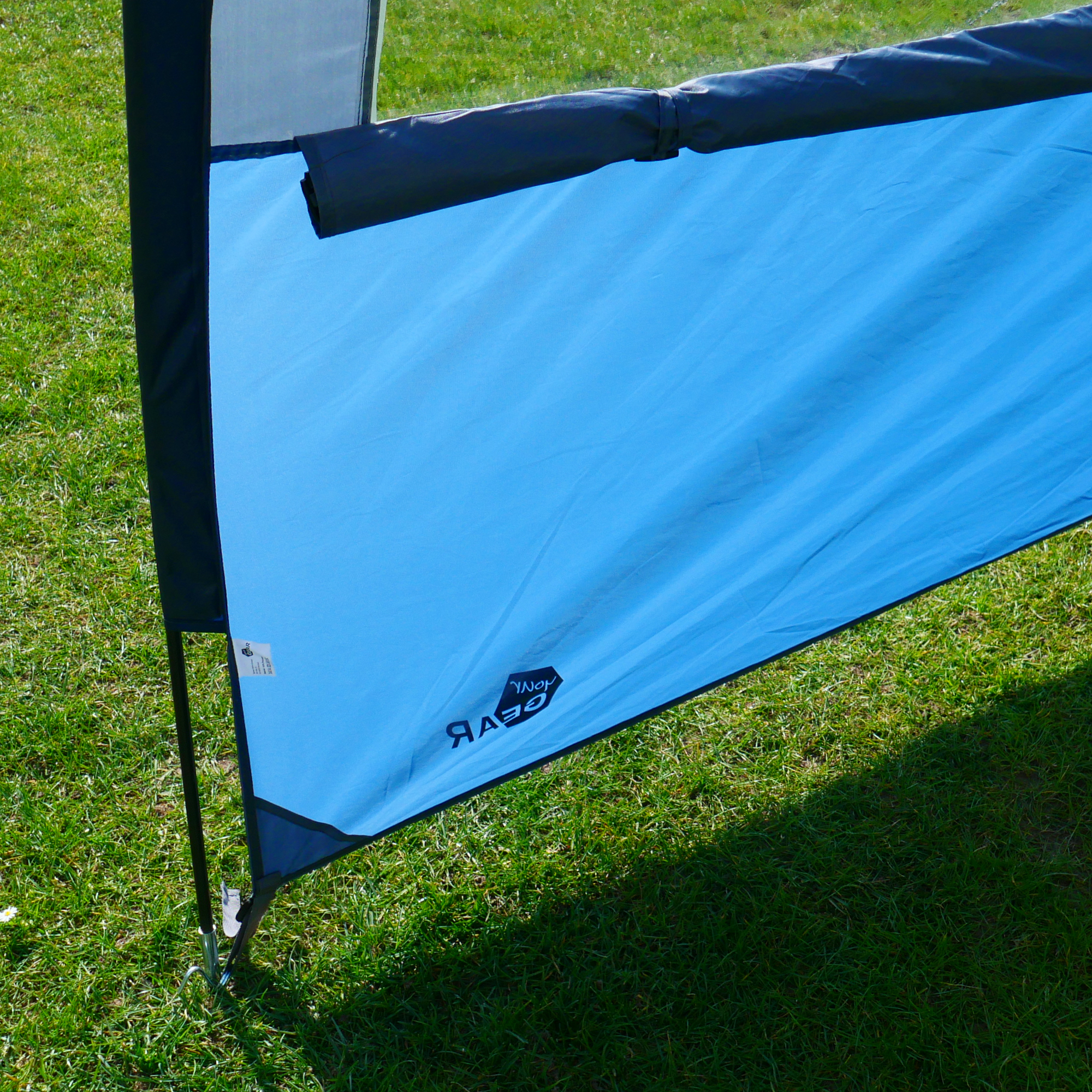 Auvent your GEAR Riviera 350 bleu, monté sur pelouse, avec armature métallique, tissu résistant UV 50+, conçu pour caravanes, camping-cars ou bus, idéal comme protection solaire et contre la pluie.
