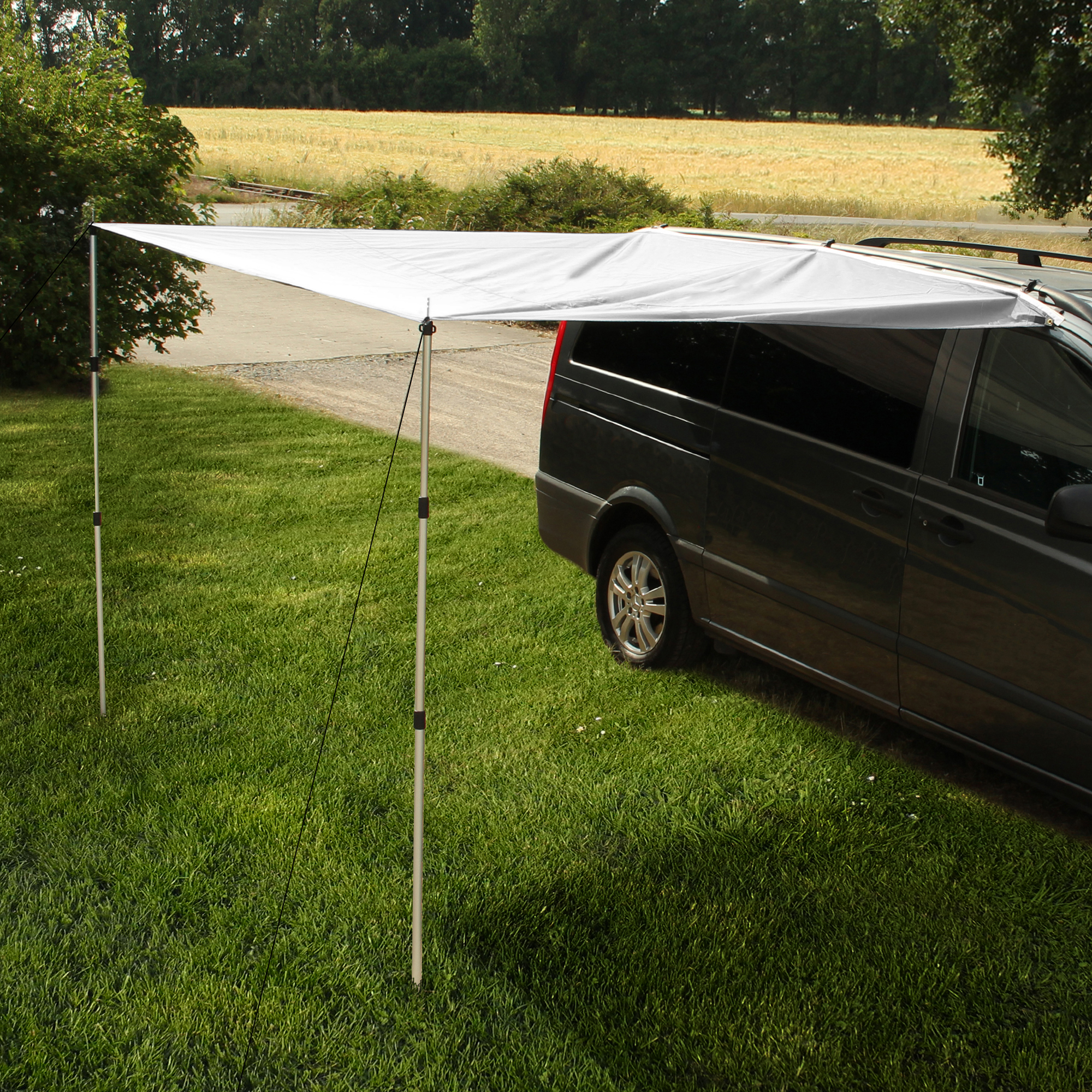 Tarp yourGEAR gris 260 x 240 cm monté sur un van noir, fixé avec deux mâts télescopiques en aluminium, offrant une protection solaire et pluie pour camping-car ou fourgon, installé sur pelouse.
