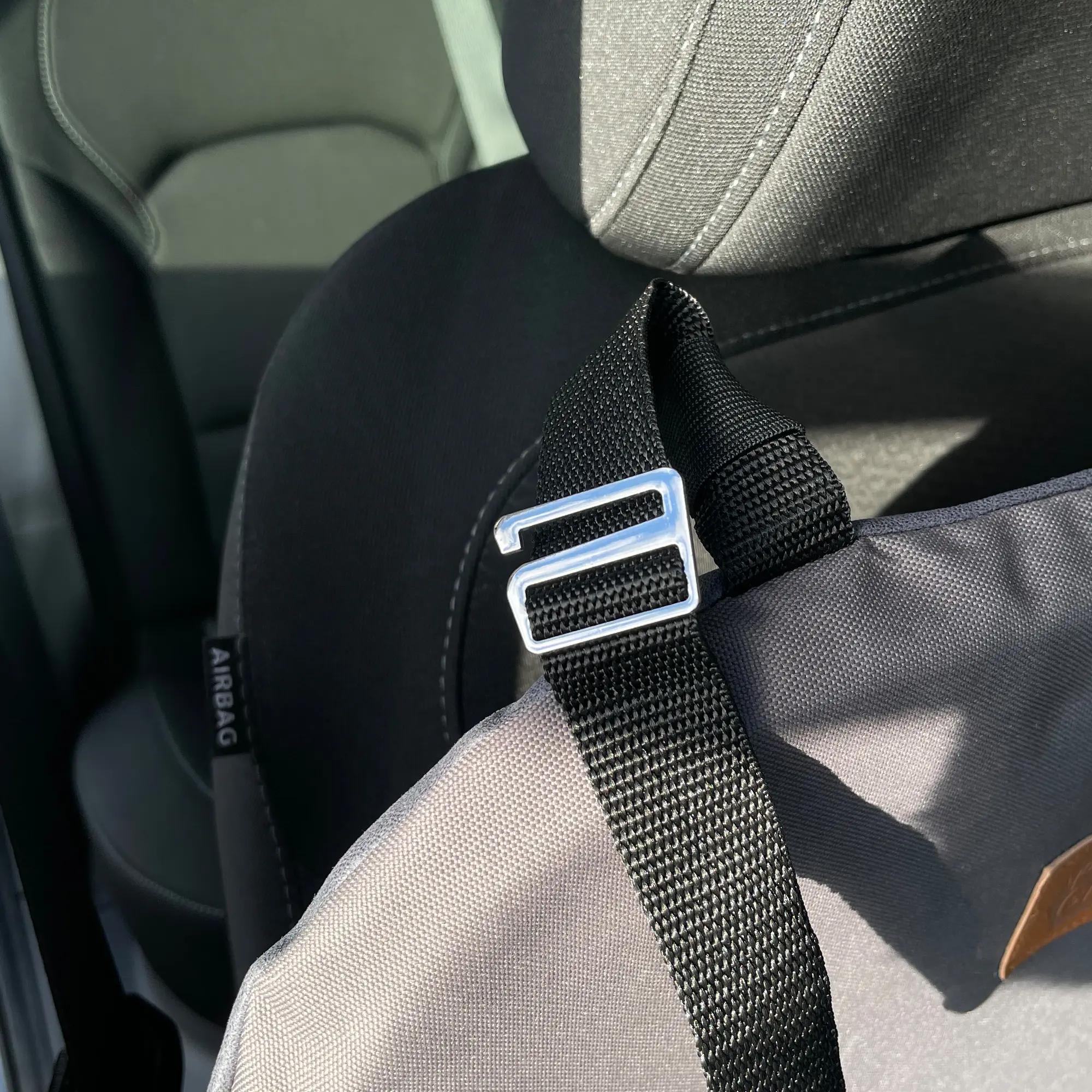 Siège auto pour chien your GEAR Frontera, fixé sur un siège de voiture avec sangle noire réglable et boucle métallique, tissu gris robuste, adapté au siège avant ou arrière pour la sécurité des chiens.