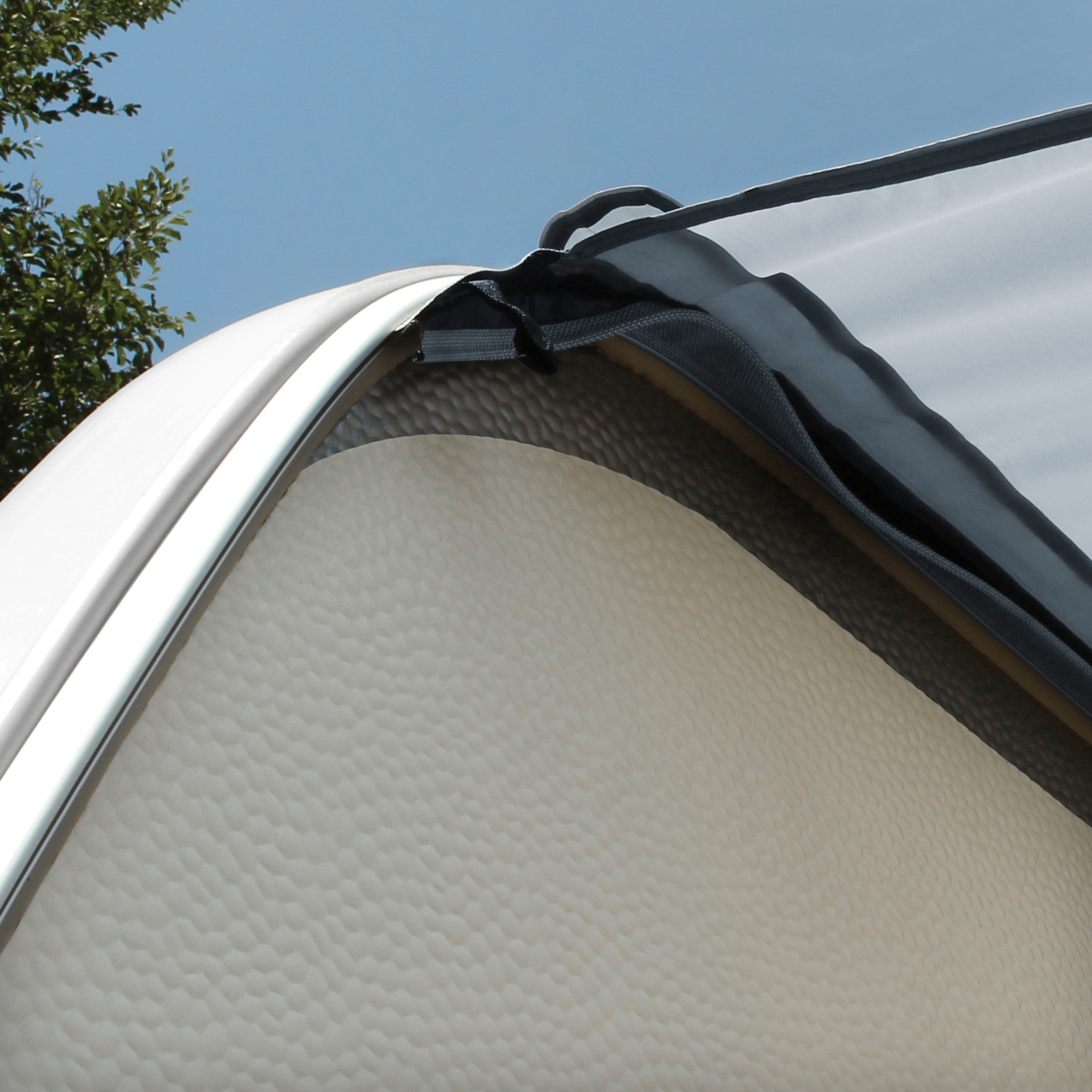 Toldo para caravana yourGEAR de 3x2,4 m en color gris, fijado al lateral de un remolque, muestra material resistente con protección UV 50+ y fácil instalación, ideal como protección solar y contra la lluvia.