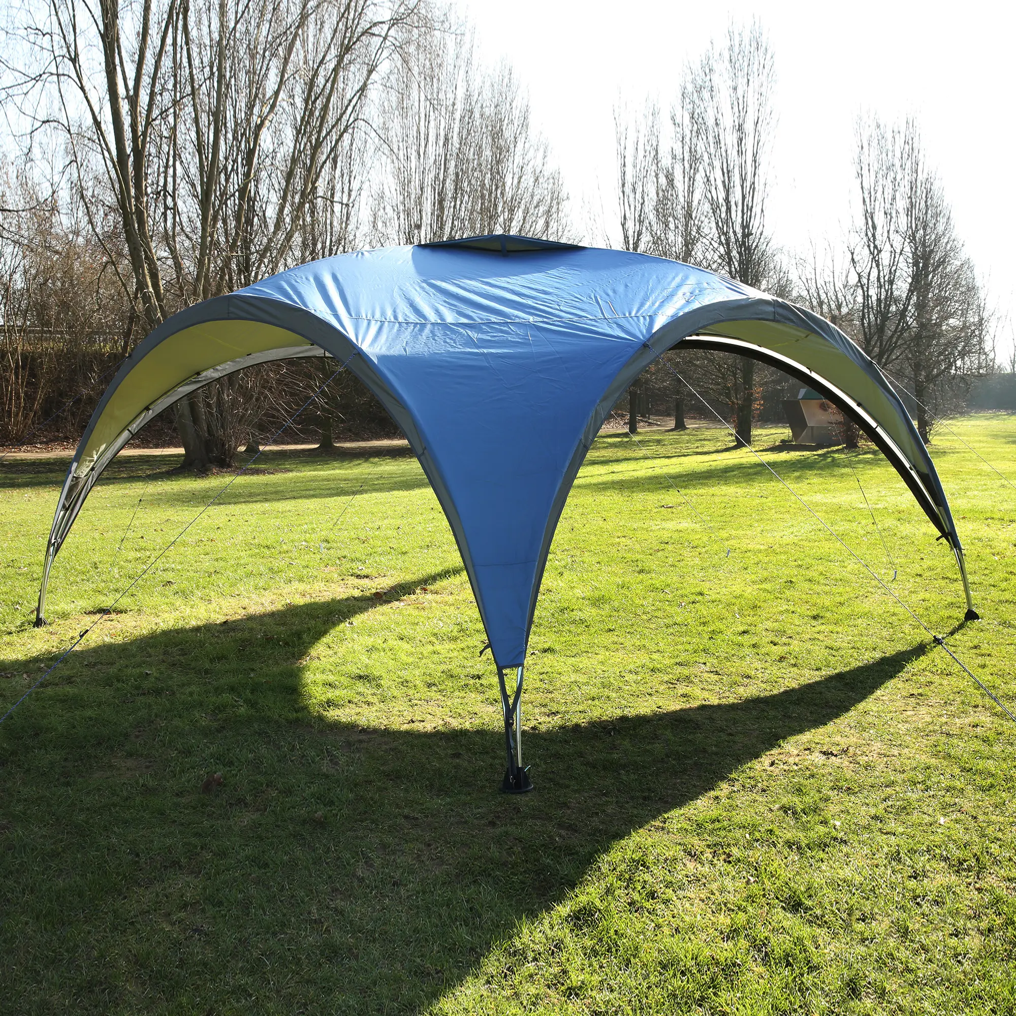Pavillon your GEAR Bergamo 430, 430x430 cm, mit blauem, wasserdichtem Dach aus 210D Oxford-Gewebe, UV 50+, stabilem Gestänge und offenen Seiten, auf einer Wiese im Freien aufgebaut.