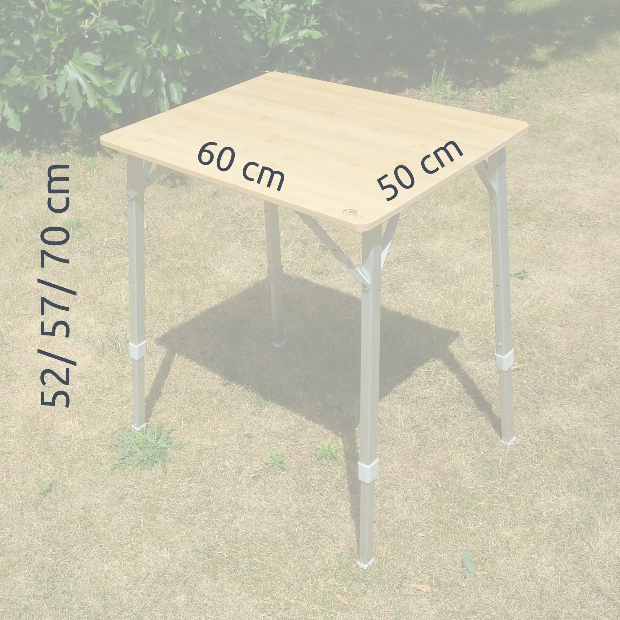 Bambus Campingtisch your GEAR Portofino M, klappbar, Tischfläche 60x50 cm, höhenverstellbar auf 52/57/70 cm, stabile Alubeine, Outdoor geeignet, für 2 Personen, auf Wiese stehend.