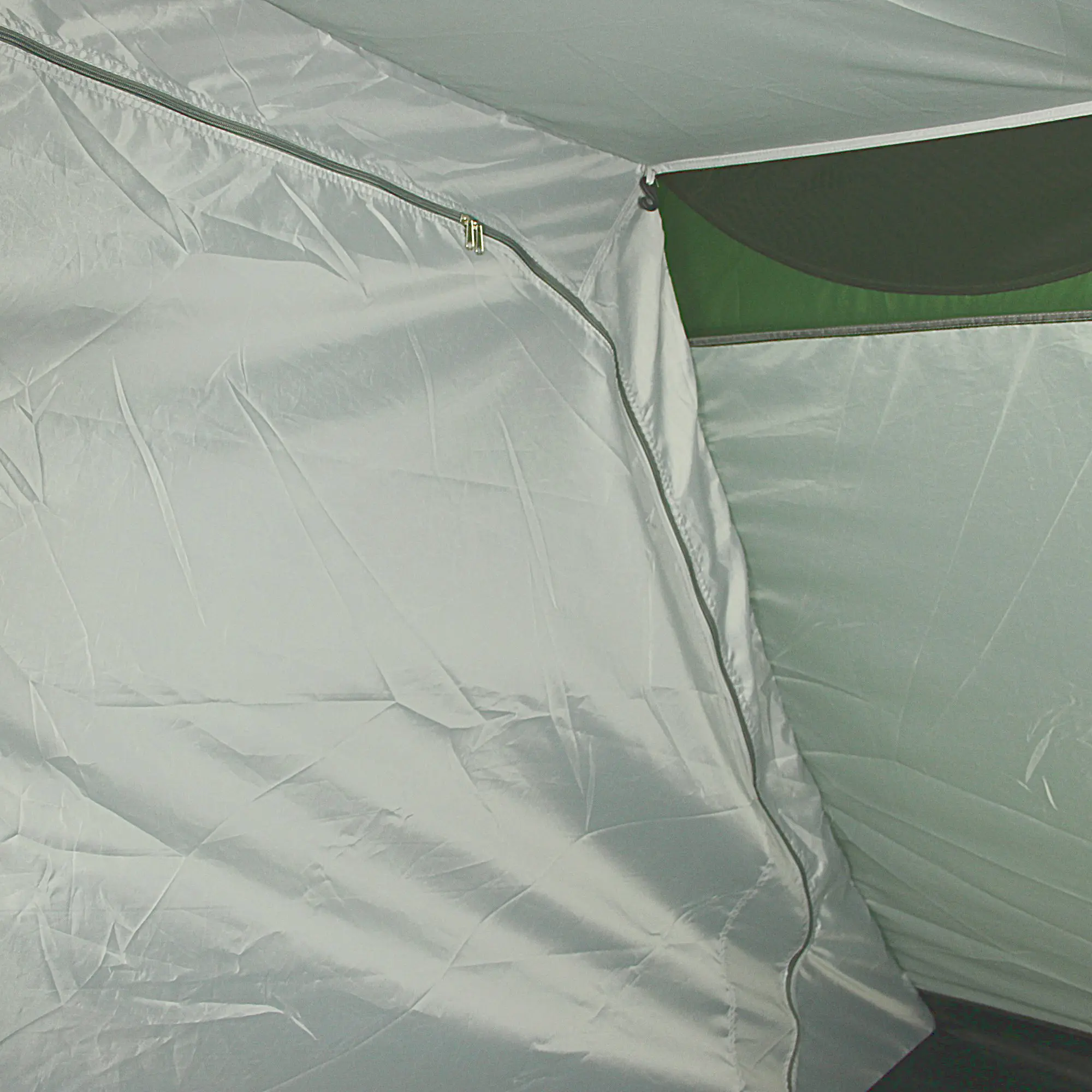Interior del Fridani DTG 5 Mann Zelt con costuras selladas, tela impermeable gris, cremallera visible y panel de ventilación verde con mosquitera, ideal para acampar en familia y protegerse de la humedad.