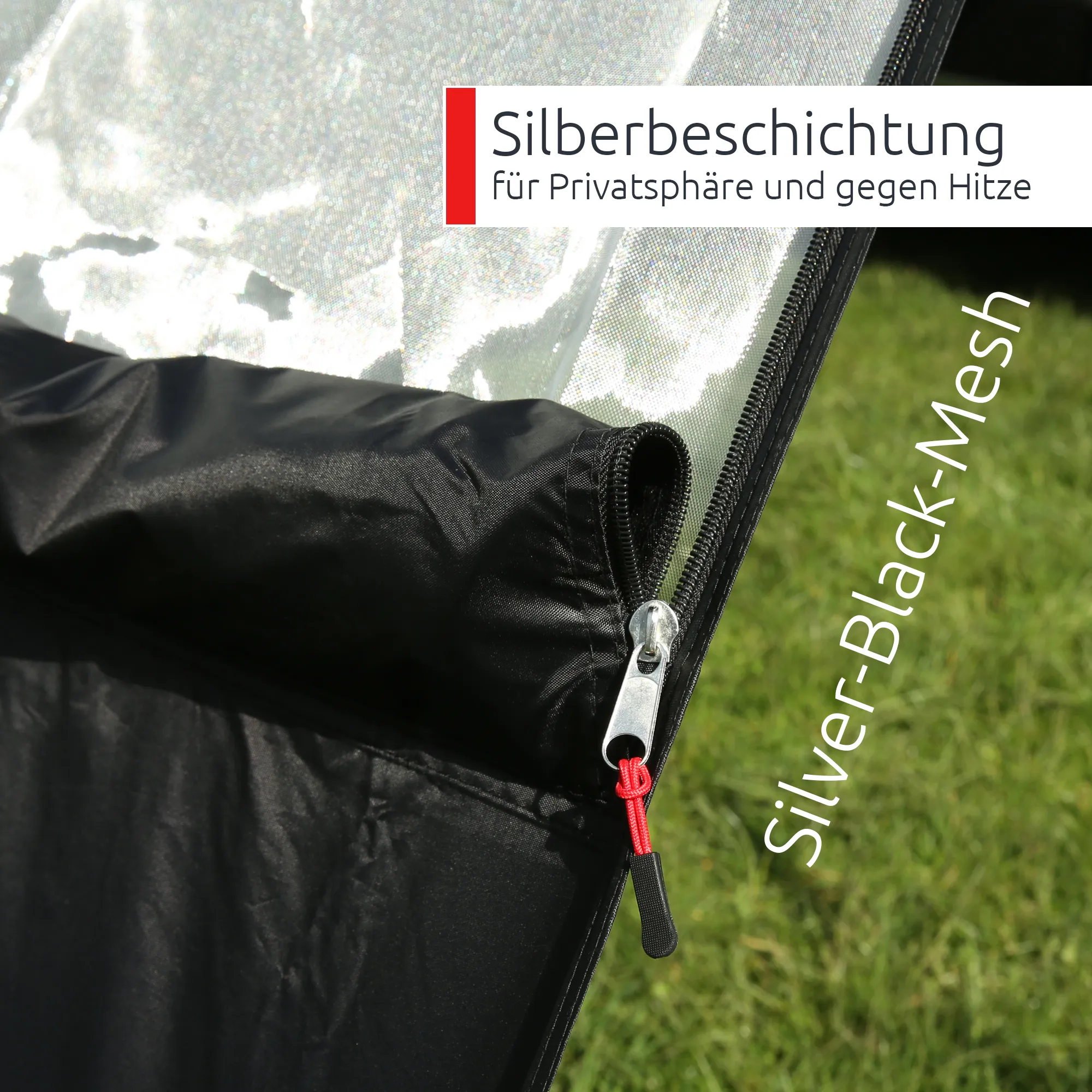 Close-up of your GEAR Phoenix Sun & Rain awning front panel in silver-black mesh with silver reflective coating, black fabric cover, visible zipper and red pull cord, shown against grassy background.
