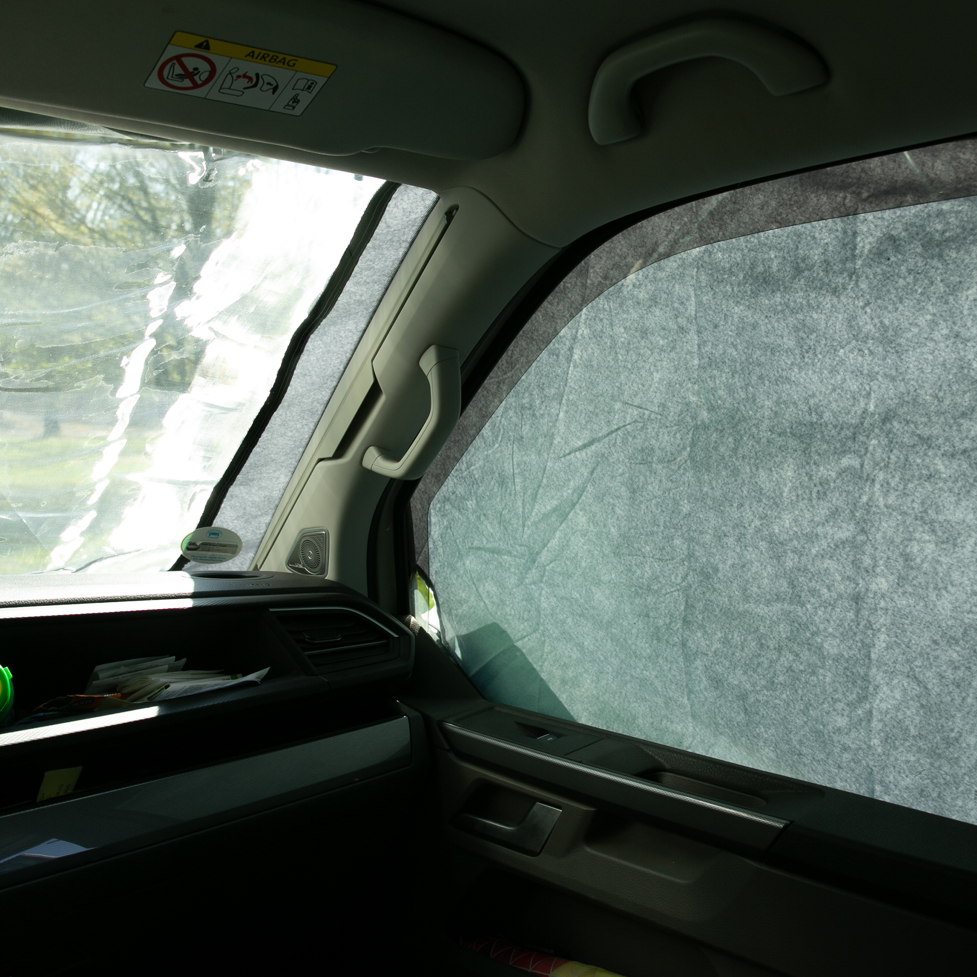 Sonnenschutzmatte your GEAR Sanremo Plus im VW T5/T6, angebracht an Seiten- und Frontscheibe, schützt vor Sonne, Hitze und Blicken, ermöglicht dabei teilweise den Ausblick nach außen.