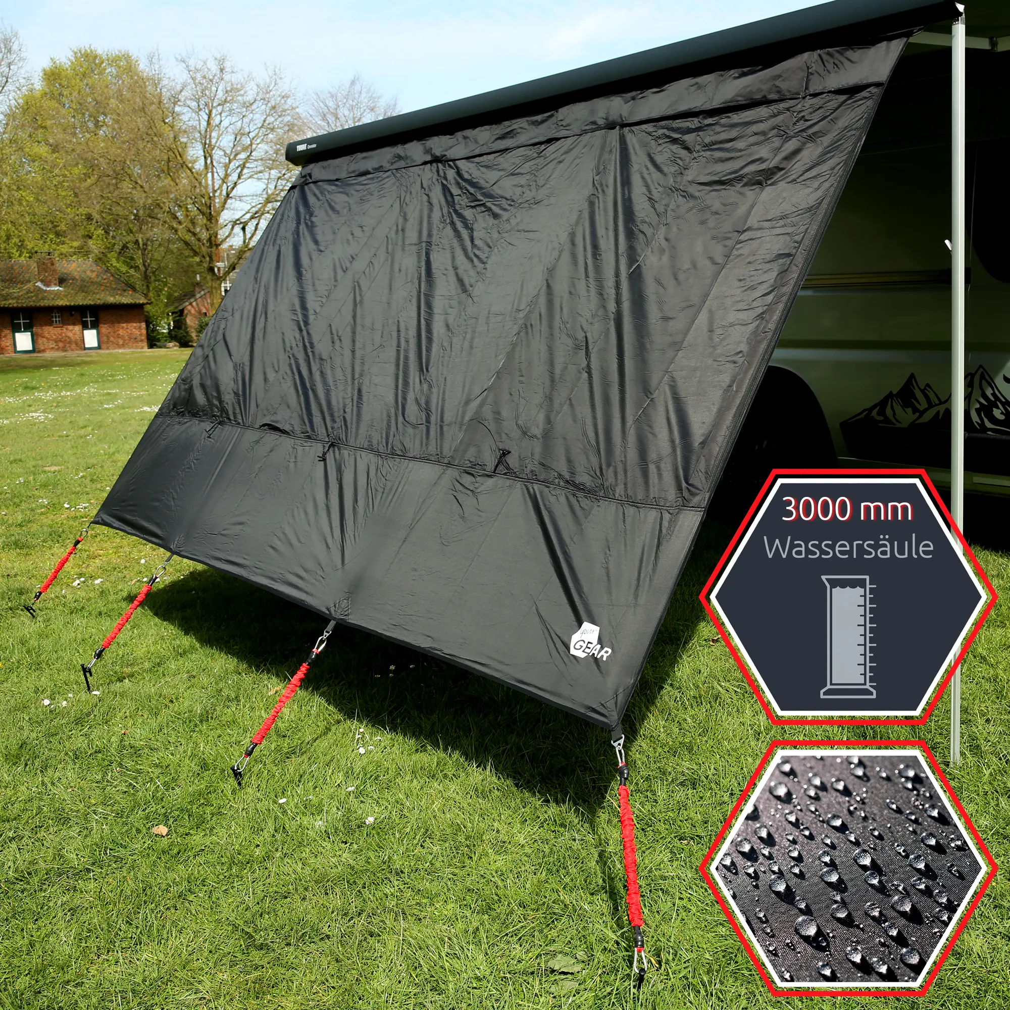 Black your GEAR Phoenix Sun & Rain awning front panel 240x200 cm with silver-black mesh look, waterproof 3000 mm, attached to caravan awning, red guy ropes and stakes visible on green grass, small your GEAR logo at bottom corner