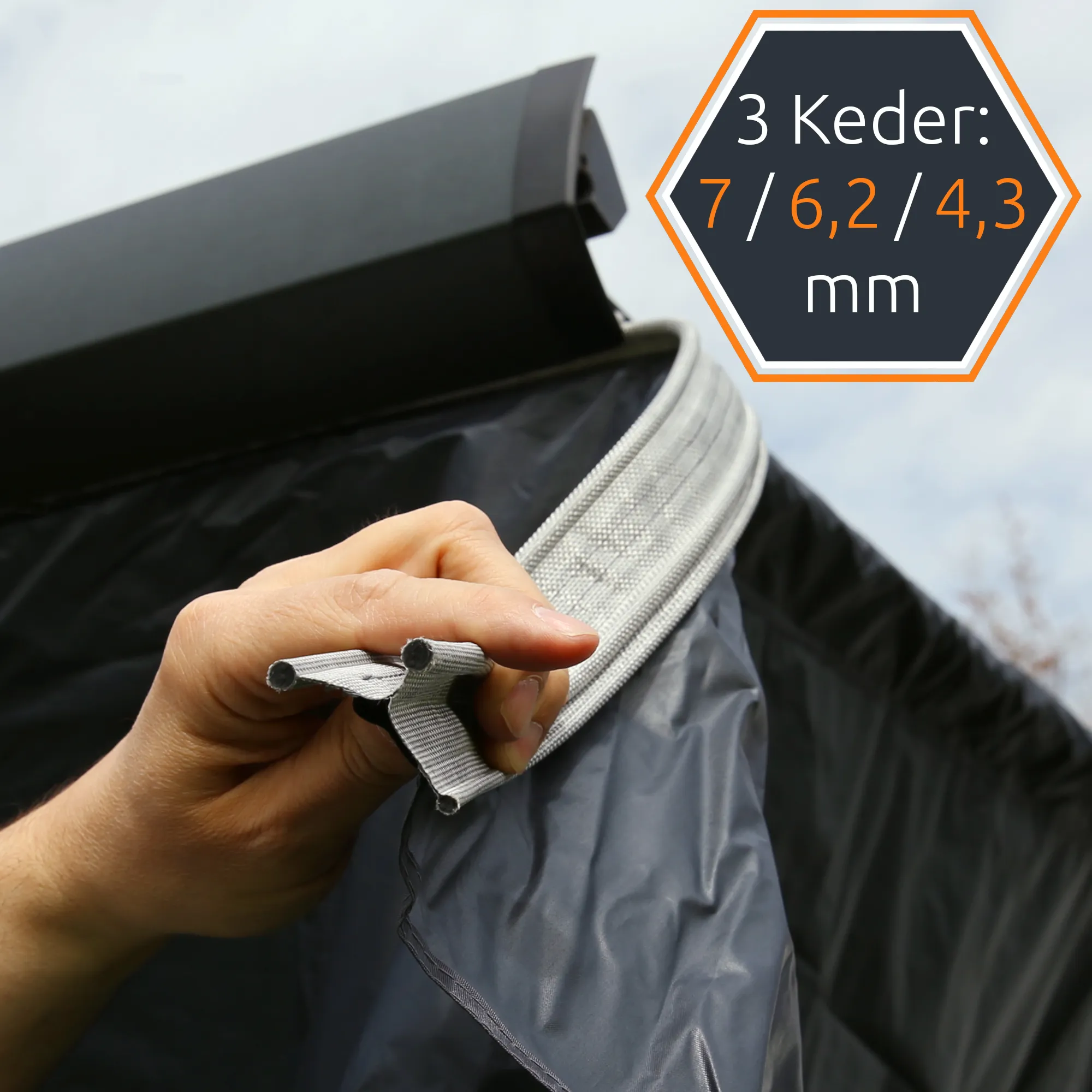 Hand holding grey PVC keder strip attached to dark grey awning front and side panels, close-up showing triple-channel keder profiles (7/6.2/4.3 mm) for your GEAR Korsika 2.4 awning walls weather protection set