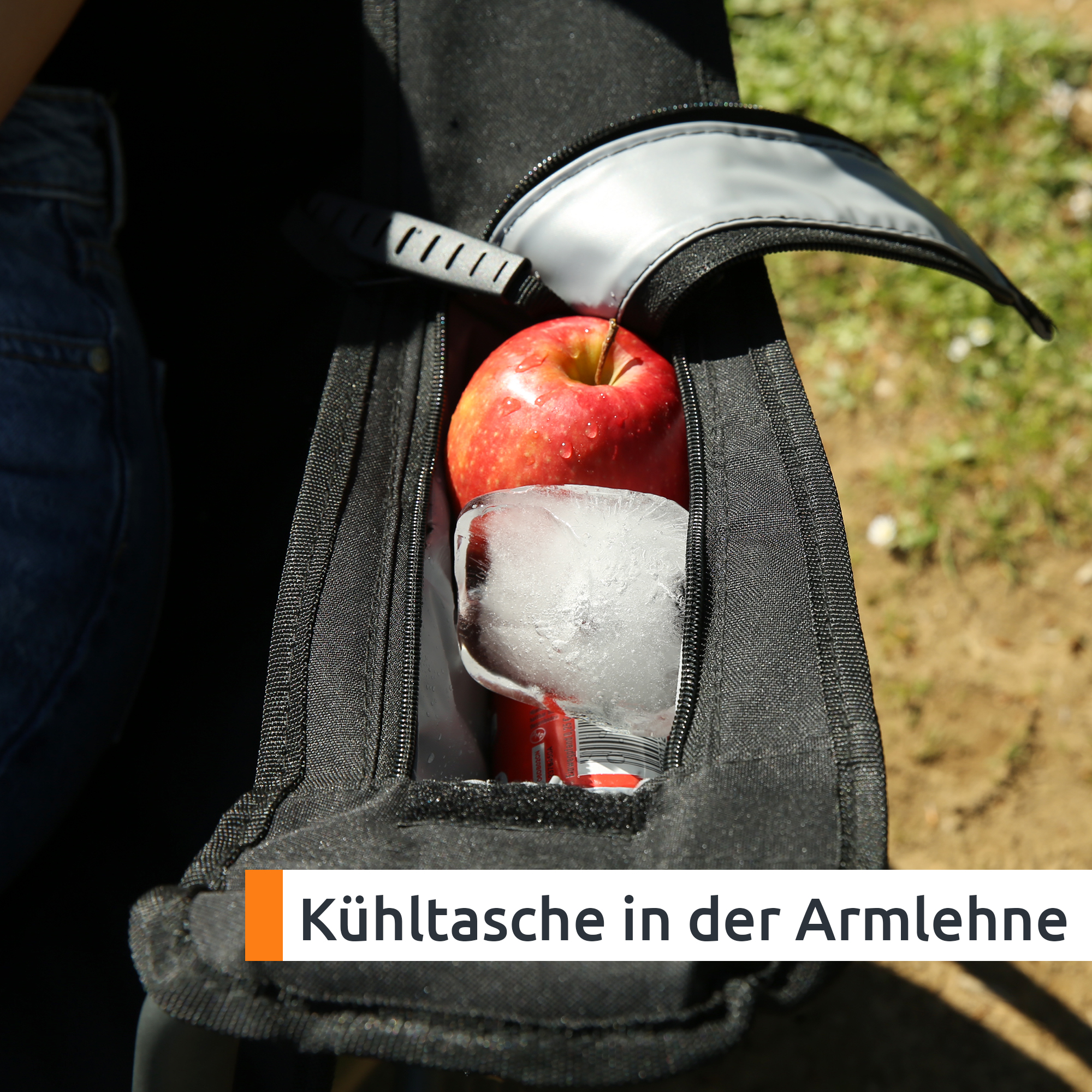Bracciolo del campingstuhl your GEAR Fano in tessuto nero con tasca frigorifera aperta contenente mela, lattina e ghiaccio, cerniera visibile e rivestimento imbottito, portabicchiere/organizer integrato.