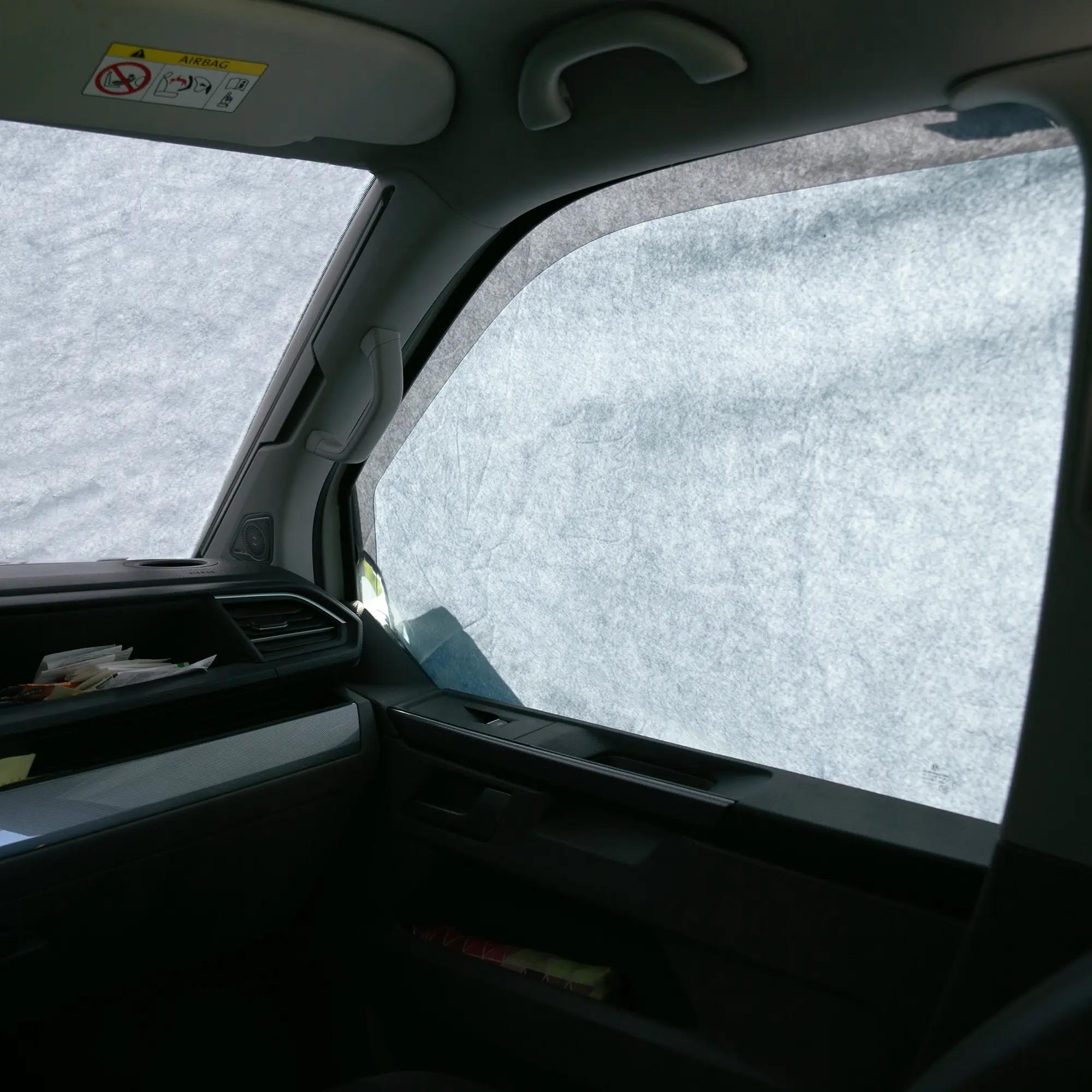 Sonnenschutzmatte your GEAR Sanremo für VW T5, T6 und T6.1, blickdicht an Front- und Seitenscheiben im Fahrzeuginnenraum angebracht, schützt effektiv vor Sonne und Hitze, silber-reflektierende Oberfläche.