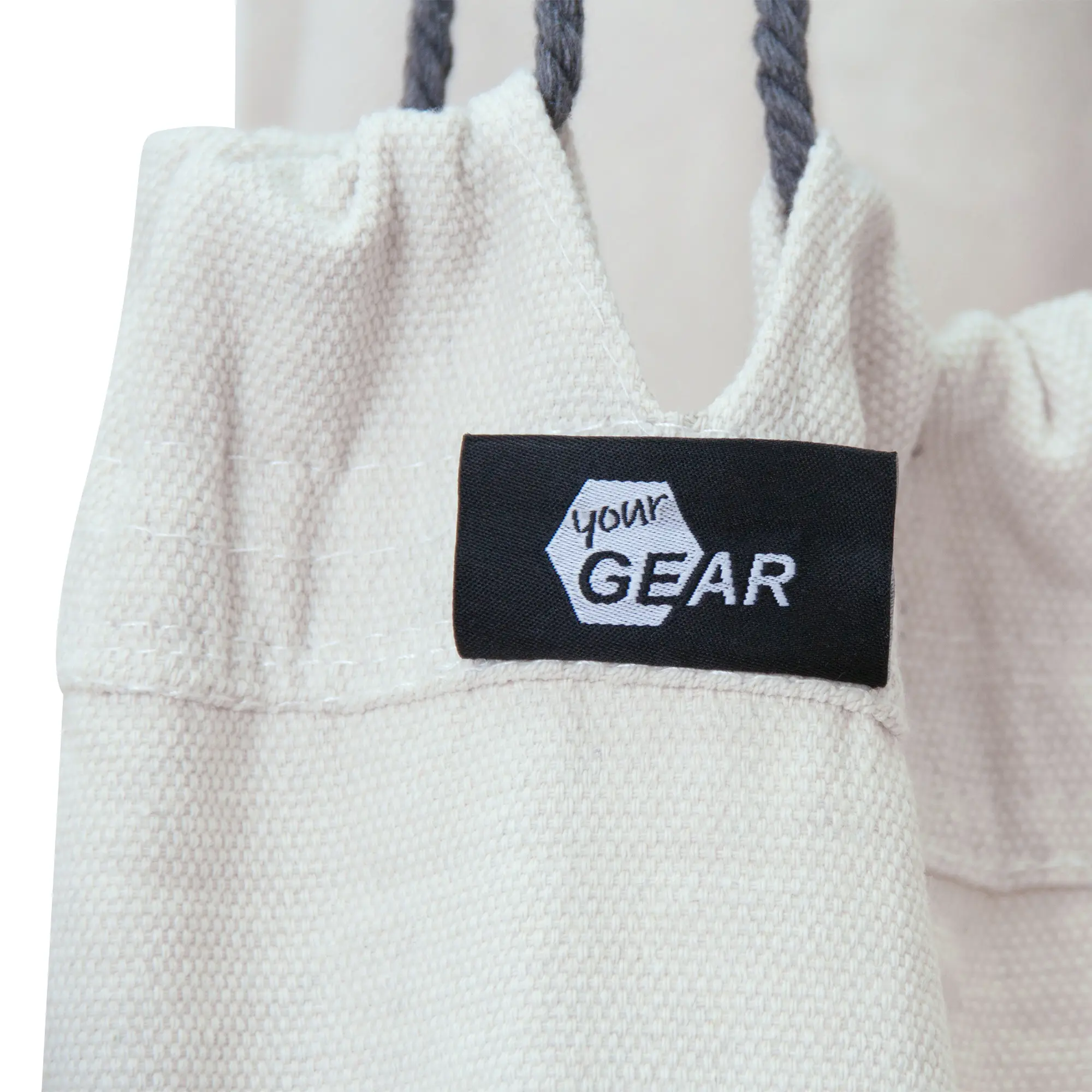 Close-up of the yourGEAR Elba XL hanging chair in beige with sturdy fabric, thick seams, and the yourGEAR brand label. Visible hanging ropes indicate strong construction for up to 240kg load.