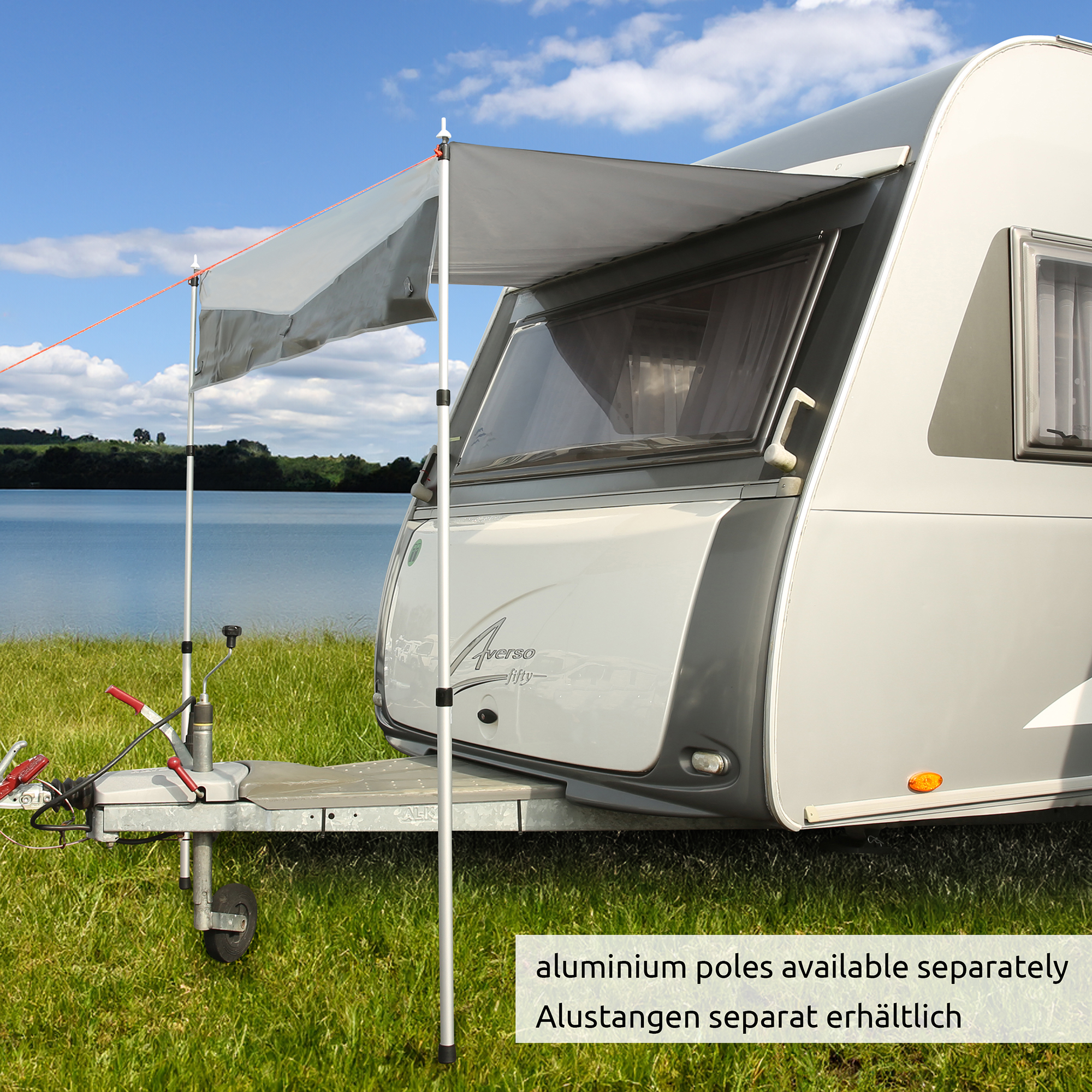 Thermal caravan bug protection cover by your GEAR, 200 x 160 cm, mounted on the front window of a caravan; grey weatherproof material, shown as sunshade; aluminium poles not included; lakeside background.