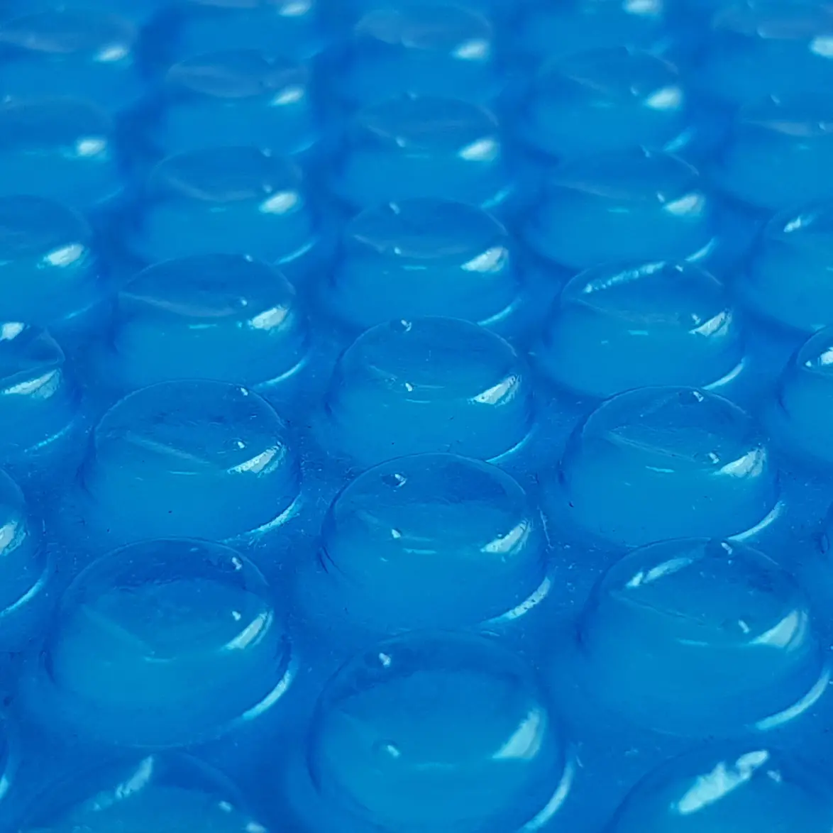 Dettaglio della yourGEAR Solarplane SC-Ø-305: struttura in plastica blu con bolle rotonde in rilievo, tipica della copertura solare per piscina da 300 µm, utilizzata per riscaldare l’acqua tramite energia solare.