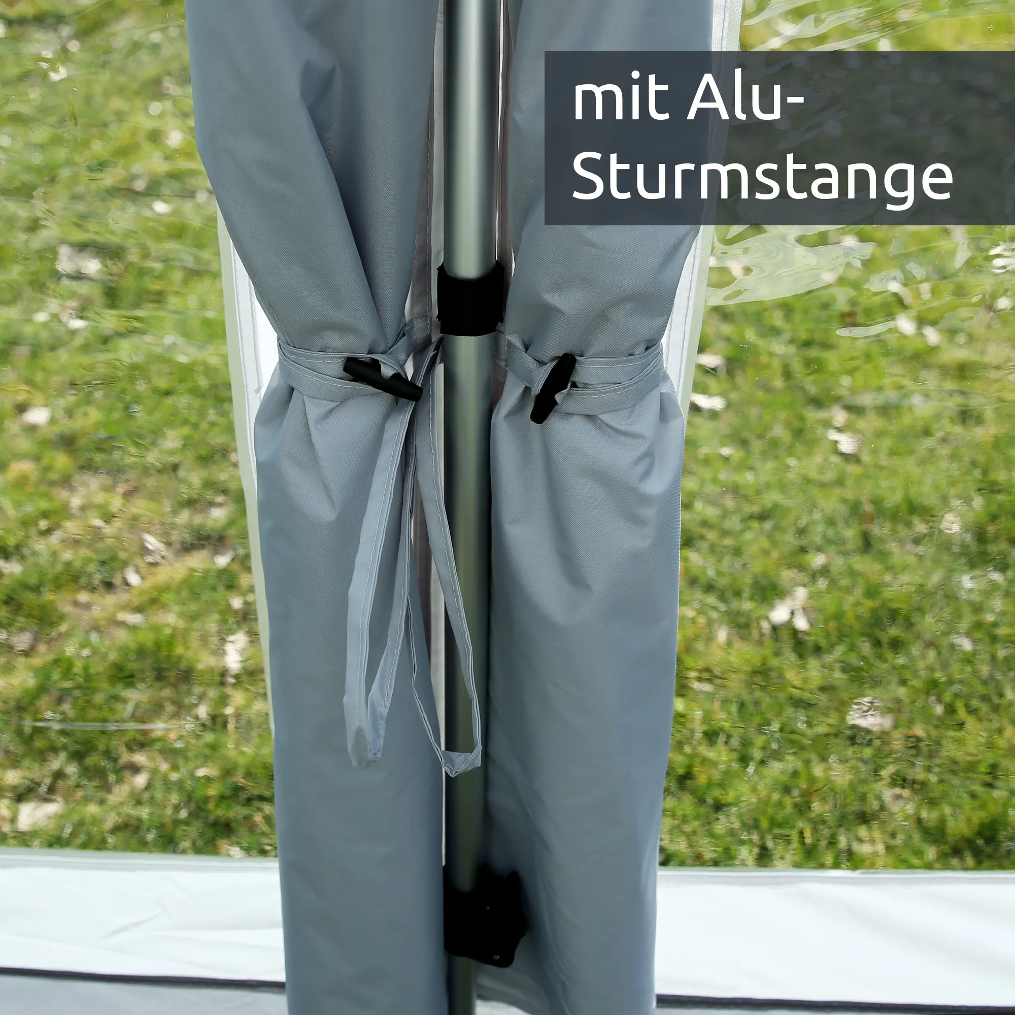 Poteau en aluminium central et rideaux gris attachés d’un auvent gonflable your GEAR Brela Air 360 pour caravane beachy 360, vue rapprochée sur les fixations et la fenêtre panoramique transparente.