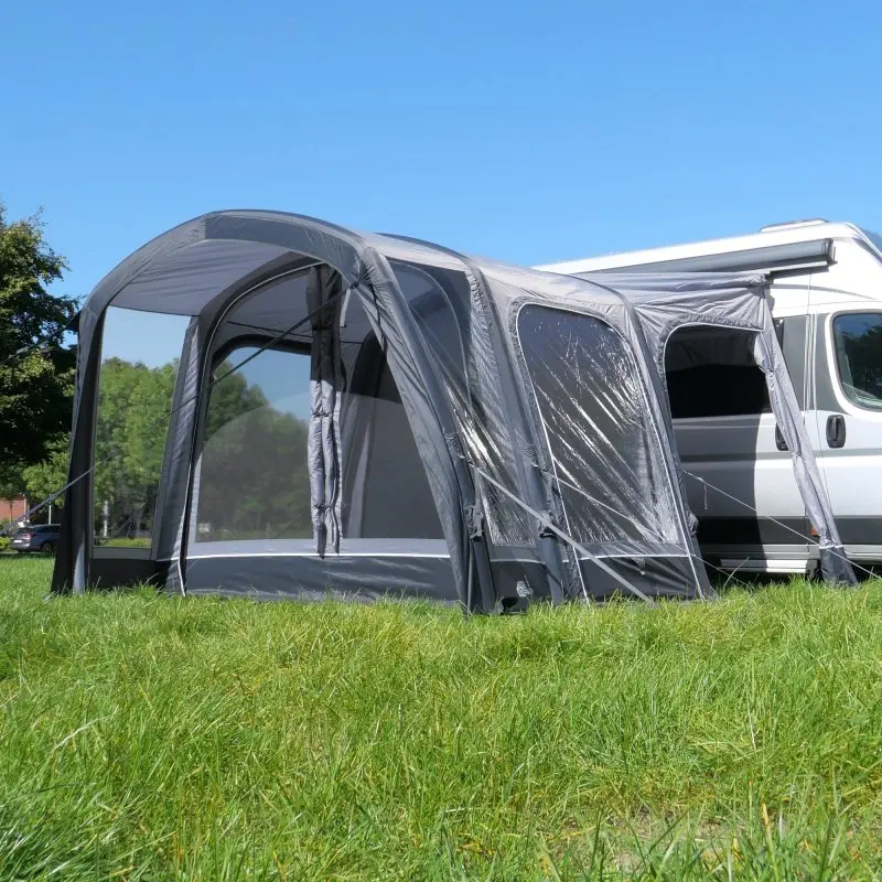 Avance de aire your GEAR Manarola Air Camper, gris, inflable, 320 x 325 cm, conectado a furgoneta camper blanca, ventanas grandes y puerta lateral, instalado sobre césped bajo cielo despejado.