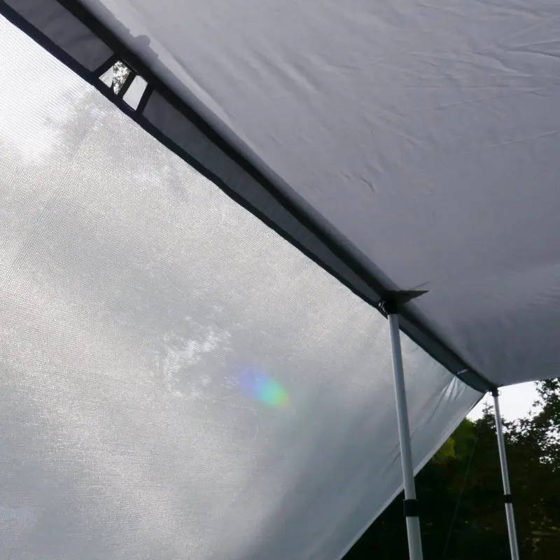Paroi avant your GEAR Procida 300x200 cm pour auvent de caravane, tissu gris clair, fixée à une structure avec des poteaux télescopiques, offrant protection solaire et intimité en camping.