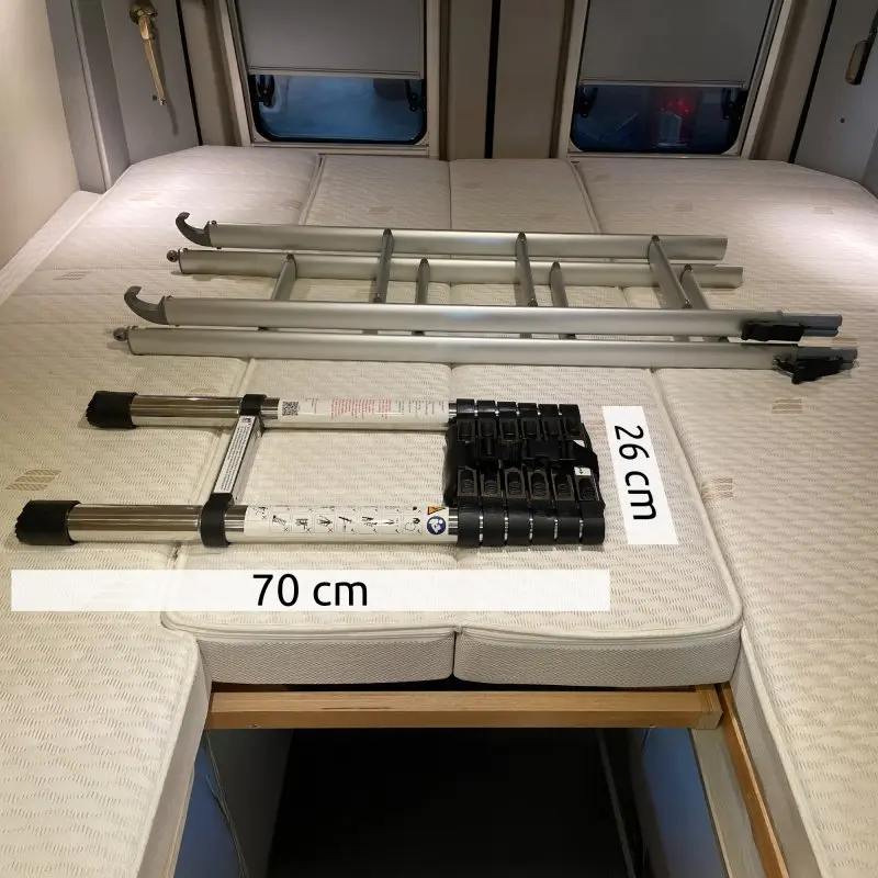 Scala telescopica your GEAR Pescara 2 m in acciaio, design compatto e stretto (26x70 cm chiusa), con ganci, ideale per tetto sollevabile di van o camper, posata su materasso all’interno di un veicolo ricreazionale.