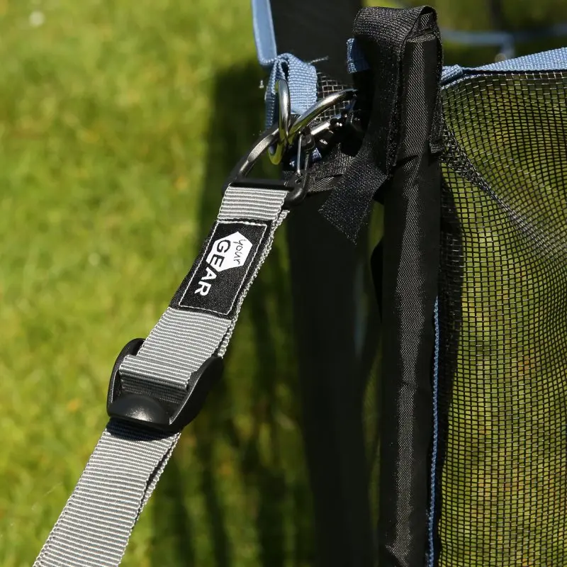 Sangle tempête grise your GEAR en polyester avec mousqueton et boucle en plastique, fixée à une structure extérieure noire, idéale pour tentes et auvents. Largeur 25 mm, longueur 250 cm, résistante aux UV.