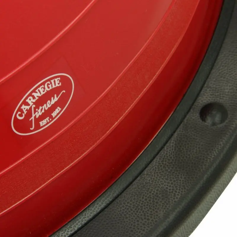 Close-up of the red Carnegie Balance Ball balance trainer with visible black textured base and Carnegie Fitness logo, designed for stability exercises and strength training with resistance bands.