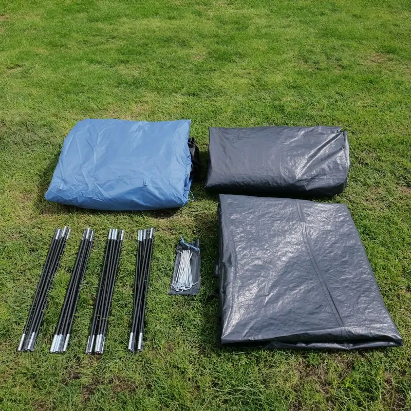Contenu du your GEAR Zelt Mistral 6 personnes : tissu de tente bleu et noir plié, arceaux en fibre de verre, piquets, prêt pour montage sur herbe. Idéal pour camping familial, protection UV 50+, 3000 mm colonne d’eau.
