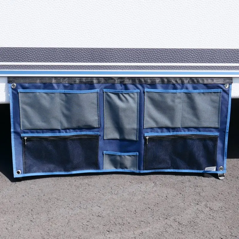 your GEAR Caravan Organizer Wide, hanging shelf for caravans or tents, 45 x 100 cm, blue and grey, with 6 compartments, metal eyelets for mounting, shown attached to a caravan wall.