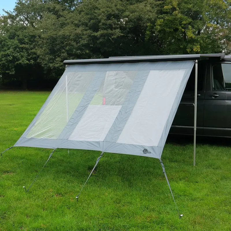 Pared frontal your GEAR Panorama Wall 2,4 x 2 m, instalada en una furgoneta como protección contra sol, viento y lluvia; tela gris, ventanas transparentes y sujeción con cuerdas. Ideal para camping.