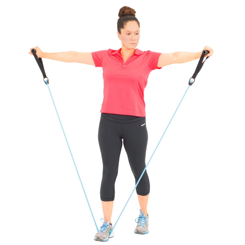 Woman exercising with Spirit Expander Light 9kg fitness resistance band, holding black handles, blue band under feet, standing upright, demonstrating home gym strength training. Ideal for effective workout and endurance training.