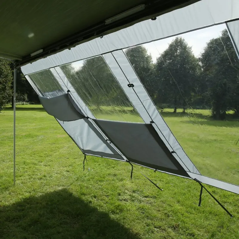Panorama Markisenwand your GEAR 4,3 x 2 m als Vorderwand mit großen, transparenten Sichtfenstern und grauen Windschutz-Elementen, montiert an einer Markise, bietet Schutz vor Sonne, Wind und Regen.