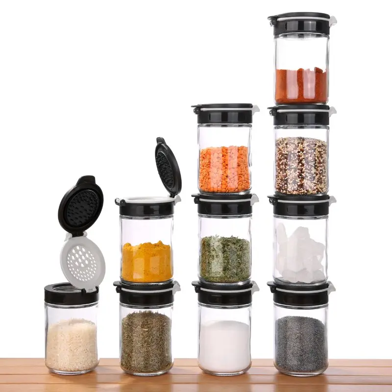 10 your GEAR Gewürzstreuer Double-Flip aus Glas, je 200 ml, mit schwarzem Doppel-Klapp-Deckel, selbstreinigendem Streueinsatz, gefüllt mit verschiedenen Gewürzen, auf Holzoberfläche gestapelt.
