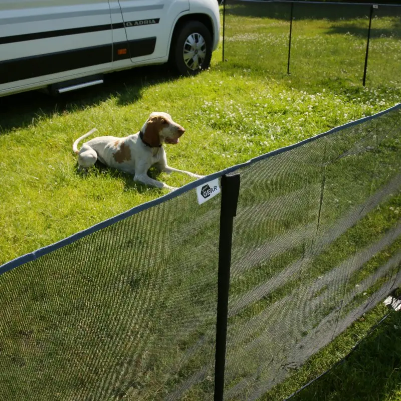 Mobile your GEAR Larino 400 dog fence, 90 cm high, mesh panels with zipper connections, set up on grass near a camper van, dog lying inside the secure, expandable outdoor enclosure for camping or garden use.