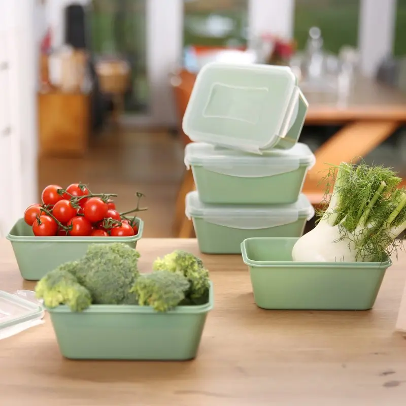 Sechsteiliges your GEAR Pila Frischhaltedosen-Set, grün, je 700 ml, mit passenden Deckeln. Die stapelbaren Dosen sind befüllt mit frischem Gemüse und stehen auf einem Holztisch in heller Küche.
