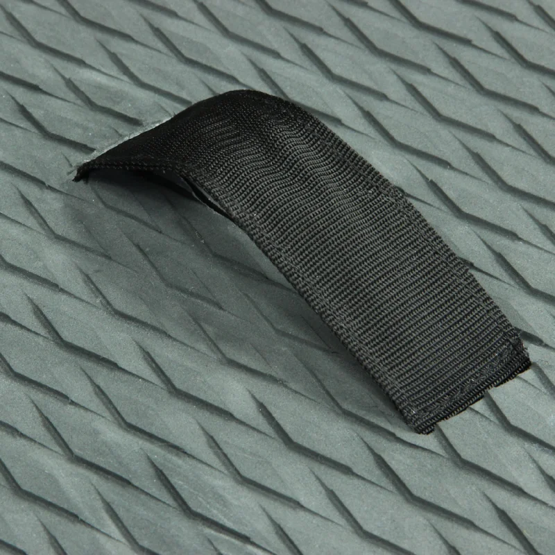 Gros plan sur une poignée en tissu noir fixée sur une surface en mousse grise à motif losange.