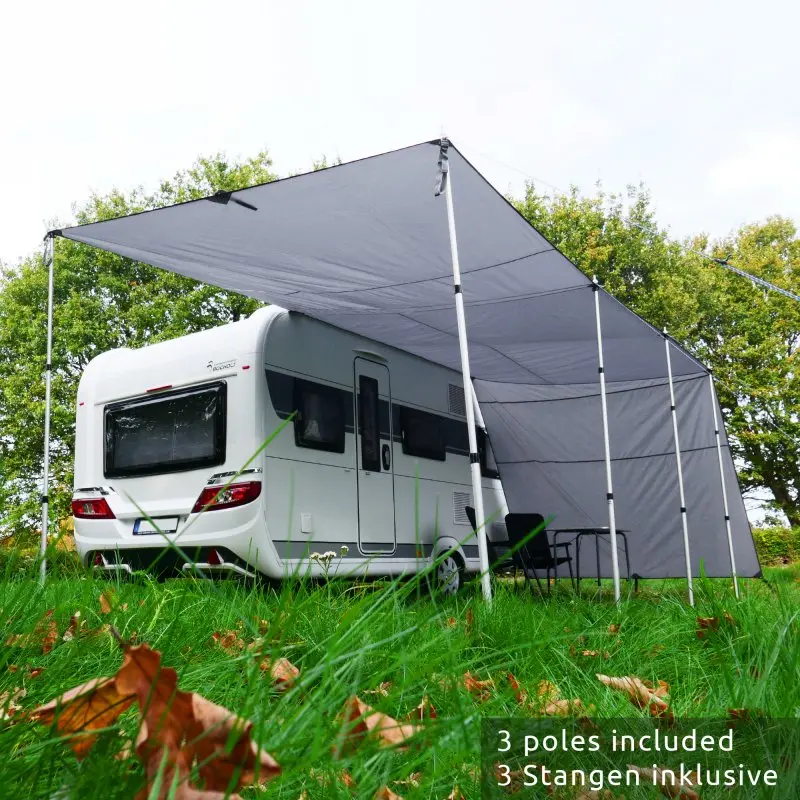 Grau-graues your GEAR Teramo 400 Sonnendach mit Seitenwänden und drei Aluminium-Teleskopstangen am Wohnwagen, bietet UV 50+ Schutz und Wetterschutz, aufgebaut auf einer Wiese mit Campingmöbeln.