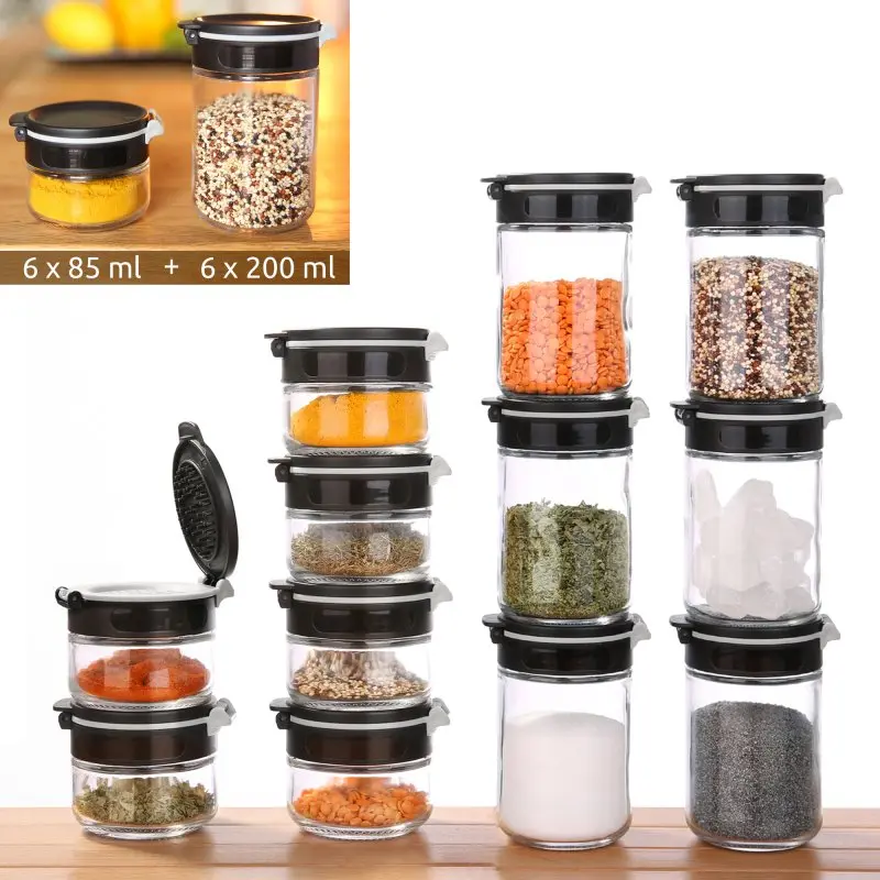 your GEAR Double-Flip spice jars set with 12 glass containers—6 x 85 ml and 6 x 200 ml—featuring black flip lids, shown filled with various spices, ideal for organized kitchen storage.