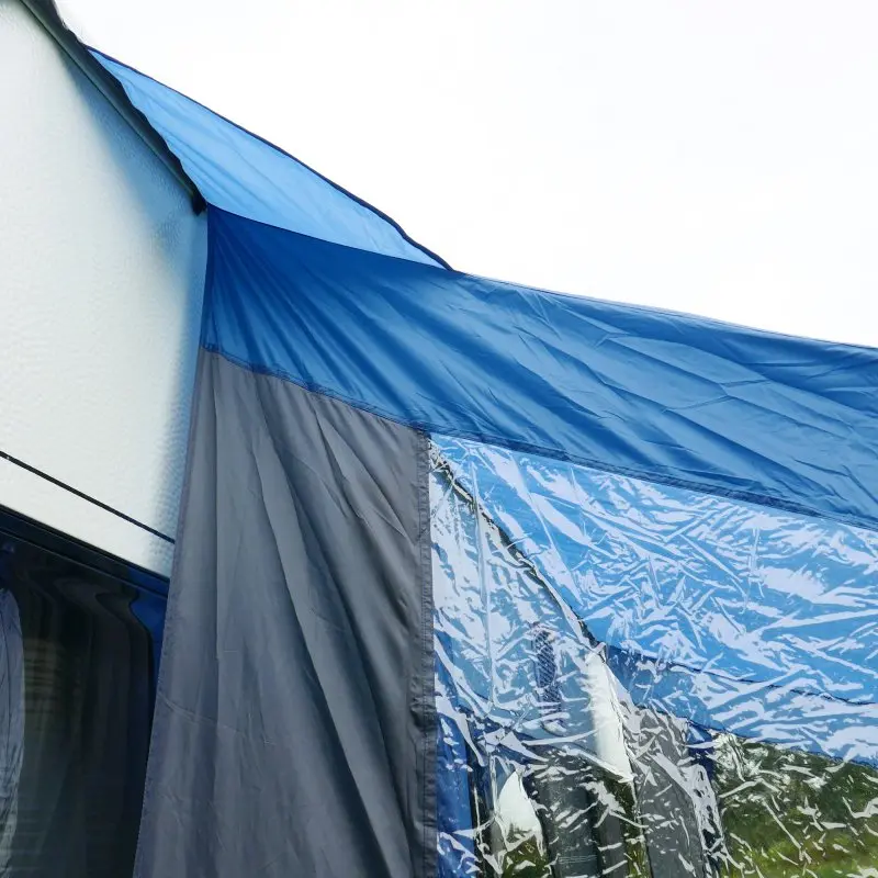 Wohnwagen Sonnendach your GEAR Sharki 330 mit Alugestänge, großem Seitenfenster aus Klarsichtfolie und robustem blauen Stoff, befestigt am Caravan; ideal als Vorzelt für Camping und Kurzurlaub.