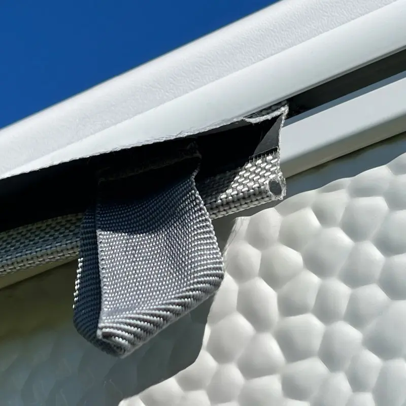 Close-up of your GEAR Caravan Thermo Tarp with aluminum coating, showing the durable Oxford polyester fabric and keder for secure attachment to a caravan, highlighting UV80 sun protection and waterproof properties.