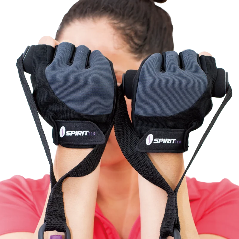 Person wearing black Spirit TCR workout gloves size S, with padded palms and adjustable straps, ideal for fitness and weight training. Gloves shown in close-up with visible brand logo on wrist closure.