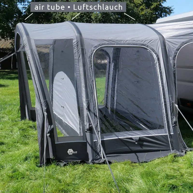 Avance de tienda hinchable your GEAR Manarola Air Camper 320x325 cm, conectada a una furgoneta, con ventanas grandes transparentes y estructura de tubos de aire, sobre césped verde. Ideal para camping y autocaravanas.