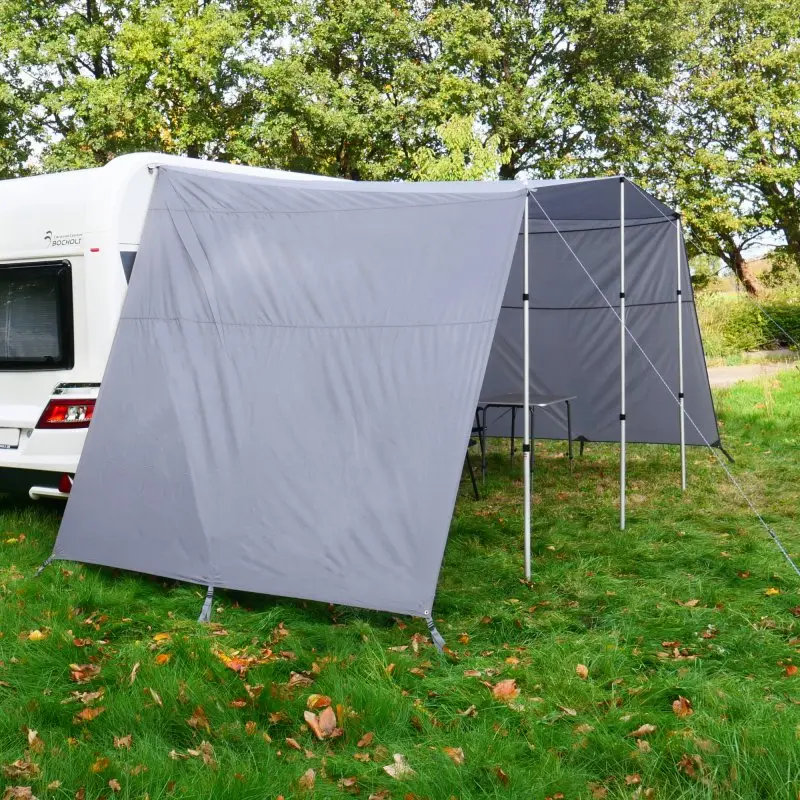 Graues your GEAR Teramo 400 Sonnendach mit Seitenwänden und Aluminium-Teleskopstangen, am Wohnwagen befestigt. Bietet UV 50+ Schutz und Wetterschutz, auf einer Wiese aufgebaut.