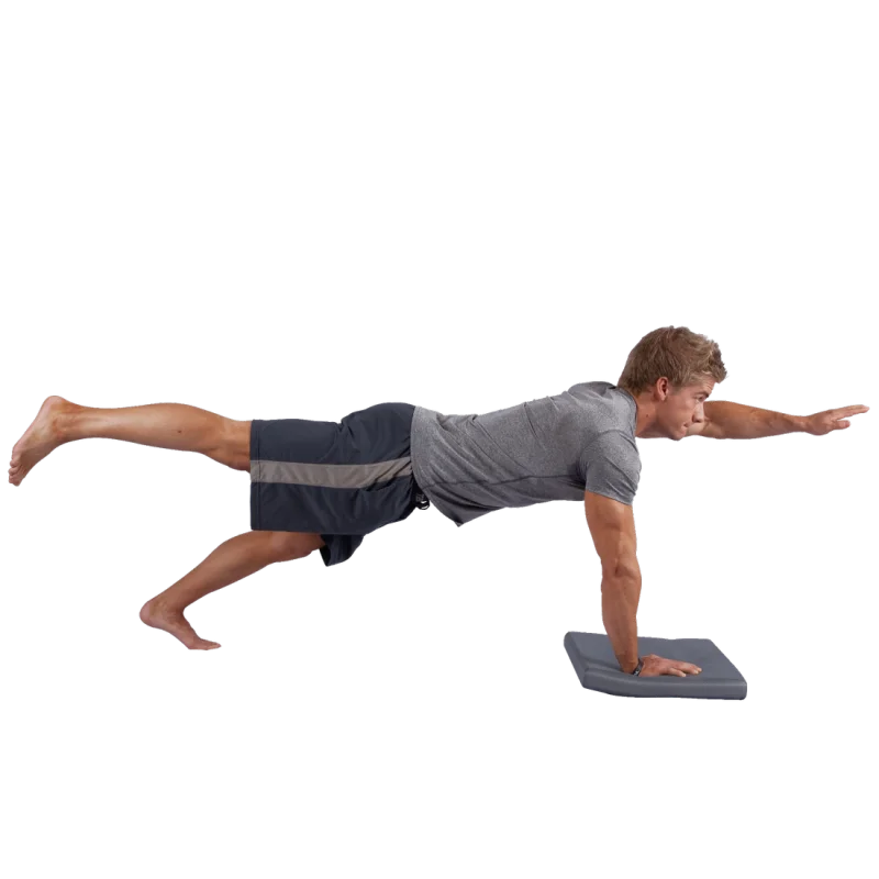 Uomo fa esercizio sulla Balance-Block XL Spirit, cuscino da equilibrio grigio 50x40x6 cm, rettangolare, usato per stabilità e coordinazione durante allenamento fitness o yoga.