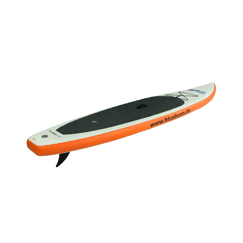 Planche de stand up paddle gonflable avec bord orange, surface noire antidérapante et filet à l’avant, vue de côté.