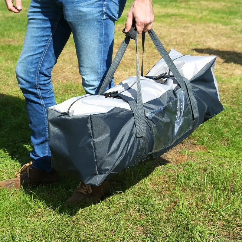 Person trägt eine graue Tragetasche mit dem your GEAR Amalfi Air 450 Caravan Sonnensegel für Hobby Beachy Wohnwagen; Tasche mit Reißverschluss und Tragegriffen, ideal für Camping und Transport.