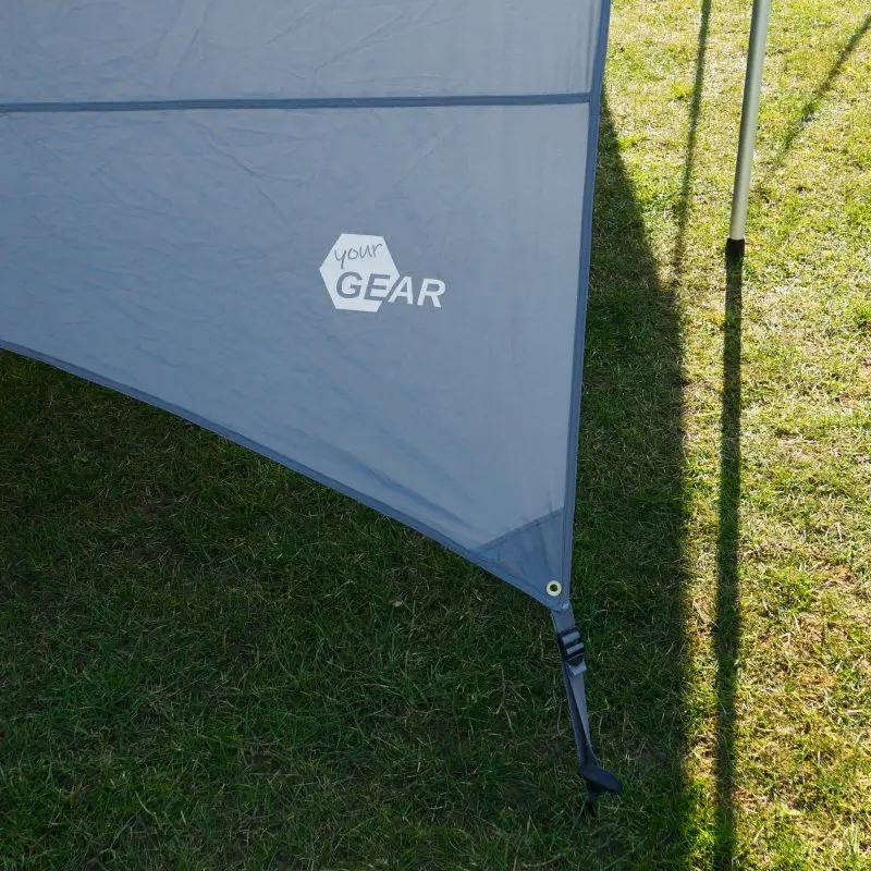 Graues your GEAR Tropea Bus Vorzelt mit Seitenwand, UV-Schutz 50+, stabilem Tarp-Stoff und Alu-Teleskopstange, aufgestellt auf einer Wiese. Ideal als Sonnensegel und Wetterschutz für Van oder Wohnmobil.