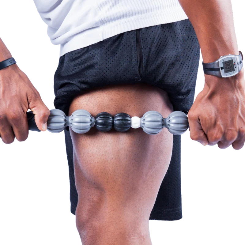 Bâton de massage musculaire Spirit, rouleau à déclenchement pour l’auto-massage, utilisé sur la cuisse. Poignées noires, rouleaux gris, noir et blanc pour soulager les tensions musculaires après le sport.