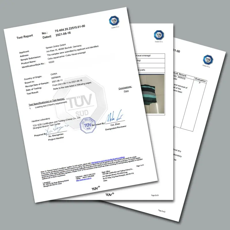 Rapport de test TÜV pour la yourGEAR Cebu Smaragd, montrant la certification de charge maximale de 300 kg pour la grande hamac en coton rayé vert et noir, pliée, avec logos TÜV visibles sur les documents.
