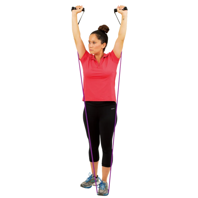 Woman using Spirit Expander Medium 13.5kg fitness resistance band for strength training, standing with both feet on the purple band and arms raised, holding handles; ideal for home workouts and gym exercises.