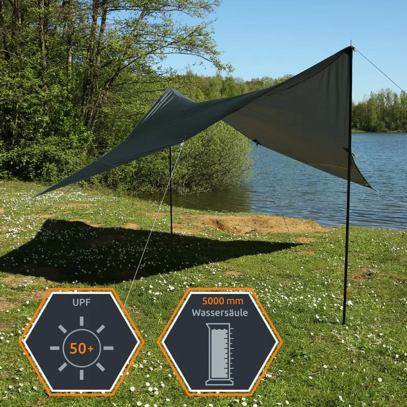 Tarp carré your GEAR Atrani 3x3 m gris-beige monté au bord d’un lac, tissu imperméable 5000 mm, deux mâts d’appui et cordes de haubanage visibles, ombre portée sur pelouse, usage camping/jardin/plage, UPF 50+.