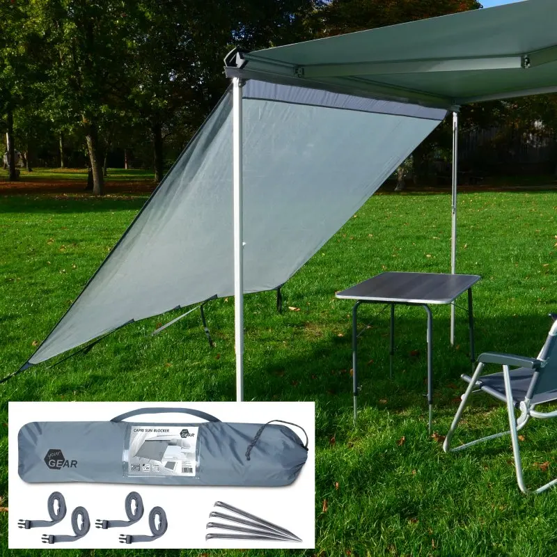 Paroi avant your GEAR Capri Sun Blocker 2,4 x 2 m montée sur une marquise de camping-car, tissu gris anti-soleil, incluse avec sac de transport, sangles et piquets, installée sur pelouse avec table et chaise.